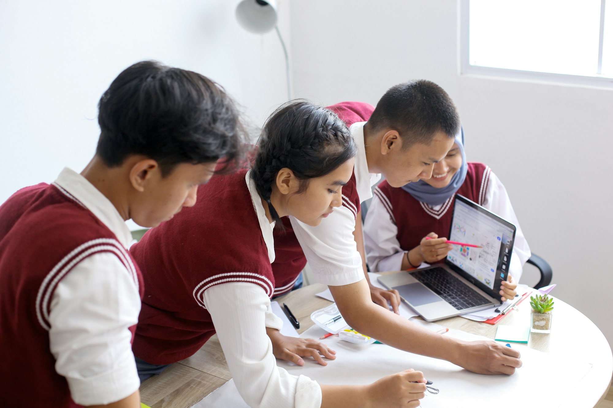 High School Students Learning With Laptop Together Preparing For School Project.